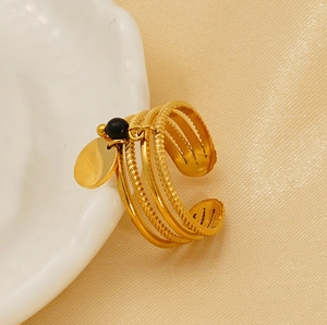 Detail of 18K gold plated multi-layer ring with black bead and round charm