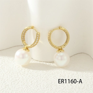 Detailed macro view of 18K gold hoop earrings with zircon pavé and white round pearls