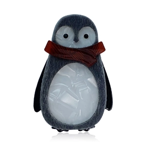 Handmade acrylic penguin brooch with grey felt texture and red scarf on white background