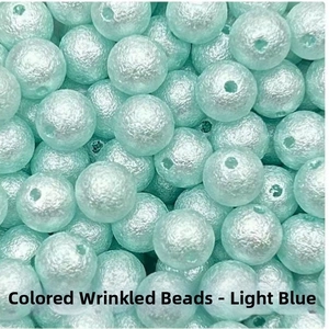 Macro shot of light blue wrinkled ABS beads showing detailed texture for DIY jewelry making