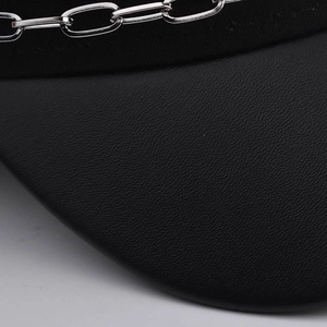 Gros plan montrant la texture du cuir PU noir de la casquette militaire avec chaîne argent