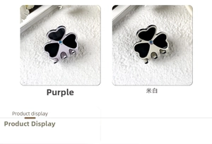 Detailed view of small acetate clover hair clips in purple and beige with rhinestones