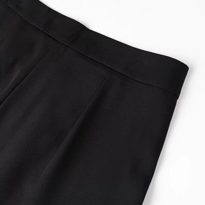 Detail of the waistband on black straight trousers with smooth fabric and stitching