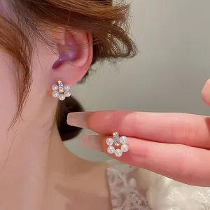 Macro shot of pearl flower earrings featuring white pearls and sparkling central rhinestones