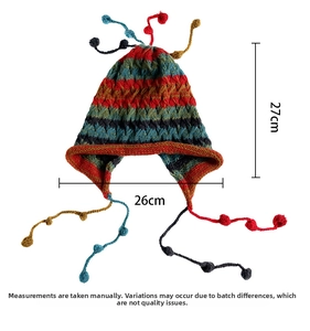 Detailed view of colorful striped knit beanie with earflaps and tassel ball accents