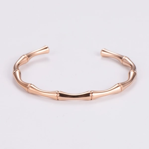 Detailed close-up of a rose gold open bangle featuring a unique bamboo knot design
