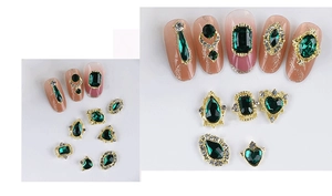Detailed close-up of emerald green zircon nail charms with gold alloy base in various shapes