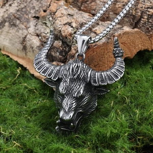 Oxidized stainless steel bull head pendant with box chain on a natural mossy background