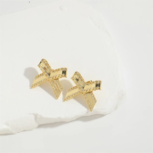Detailed macro view of gold-plated bow earrings featuring white zircon on stone