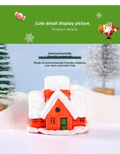 Detailed close-up of a resin Christmas house miniature with red walls and snowy roof
