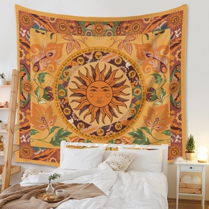 Detail of sun deity and zodiac constellations on bohemian tapestry in a cozy bedroom
