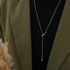 Minimalist gold long Y-necklace with knot pendant and snake chain on model