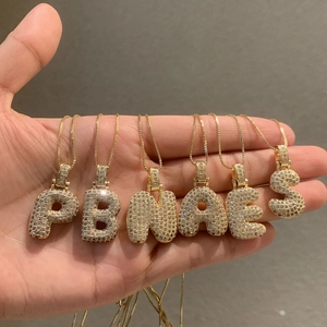 Détail des pendentifs lettres bombées dorées ornés de zircons brillants à la main
