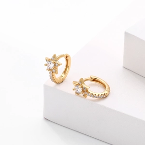 Close-up of gold S925 silver hoop earrings with zircon-studded star charms on white block