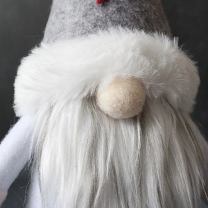 Nordic Christmas gnome plush with grey felt hat and soft white beard on dark background