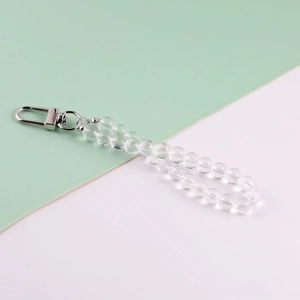 Close-up of clear beaded phone strap with silver metal clasp on pastel background