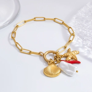 Flat lay of gold ocean themed bracelet with baroque pearl, starfish and shell charms