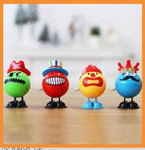 Close-up of four colorful wind-up clockwork toys on a wooden surface for party favors