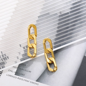 Dettaglio di orecchini pendenti a catena in oro 18K su un vassoio in acrilico