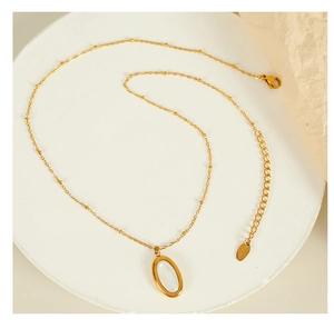 Detailed macro view of the gold necklace with white oval pendant and S.steel hallmark