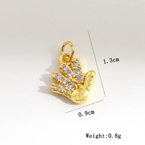 Macro detail of gold palm pendant with zircon stones and dimensions 1.3cm x 0.9cm