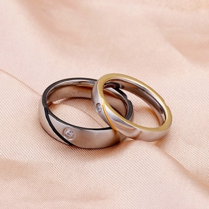Minimalist two-tone couple rings with single diamond on champagne silk background