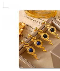 Dettaglio di orecchini a serpente in acciaio dorato 18k con pietre blu e nere