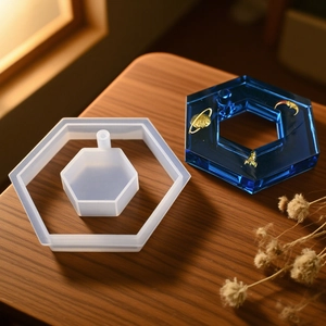 Détail d'un moule hexagonal en silicone avec pendentif en résine bleue sur bois foncé