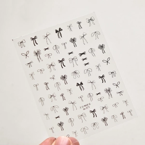 Macro detail of ultra-thin transparent nail art stickers with hand-drawn black bows ta-371