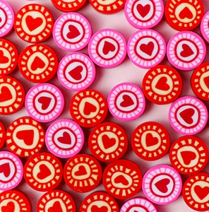 Close-up of handmade red and pink heart pattern polymer clay beads for DIY jewelry
