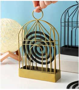 Detail of birdcage mosquito coil holder with hanging loop and ash tray in gold and black