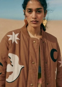 Detail einer braunen Collegejacke mit weißen Stern-Applikationen und Druckknöpfen