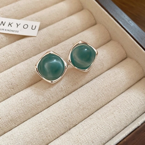 Macro view of vintage blue enamel earrings with square silver frame in velvet jewelry box