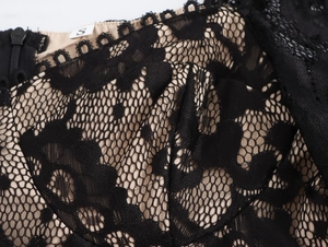 Dettaglio in pizzo nero su fodera beige con etichetta taglia S e zip invisibile