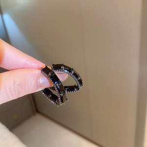 Gros plan de boucles d'oreilles créoles noires avec cristaux de zircon rectangulaires