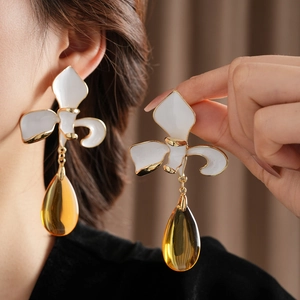 Detailaufnahme von Vintage-Blumenohrringen aus Gold mit gelben Glastropfen-Anhängern
