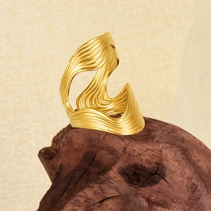 Minimalist 18k gold double-layer S-shaped wavy open ring on a natural wood block