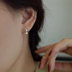 Detail of 14K gold-plated S925 silver stud with blue topaz and white round pearl