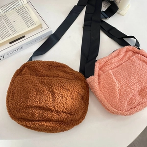 Detail view of pink and brown fleece crossbody bags with adjustable nylon straps