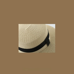 Close-up of lightweight woven straw hat featuring detailed texture and a black ribbon band