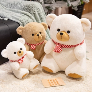 Three plush teddy bears in white and brown wearing red checkered scarves in a cozy room
