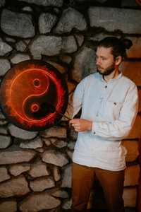 Detail showing a shamanic hand drum with a flaming Tai Chi pattern and wooden mallet