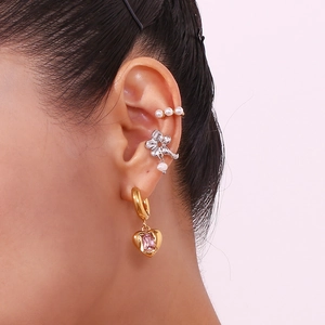 Detail of floral ear cuff and heart pendant earring with pink gemstone on model