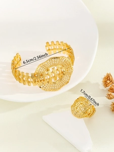 Detailed view of hollow carved gold-plated bridal cuff bracelet and open ring set