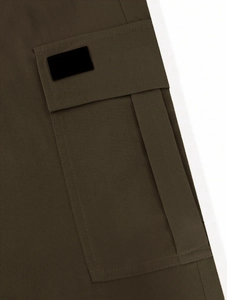 Close-up of olive cargo pants featuring multi-pocket detail and precision stitching