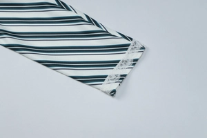 Close-up of striped long sleeve cuff with intricate white floral lace trim detail