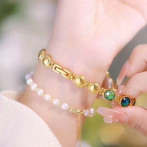 Detail of elegant gold-plated bracelet watch band with white pearls and malachite