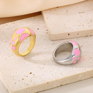 Detail of 18K gold and silver chunky dome rings with pink enamel polka dot patterns