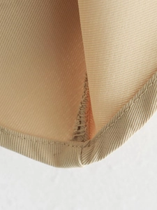 Détail de gilet kaki montrant des coutures précises et une doublure en maille respirante