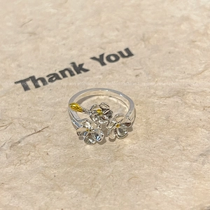 Detailed close-up of micro-paved zircon butterfly ring with delicate flower petal accents